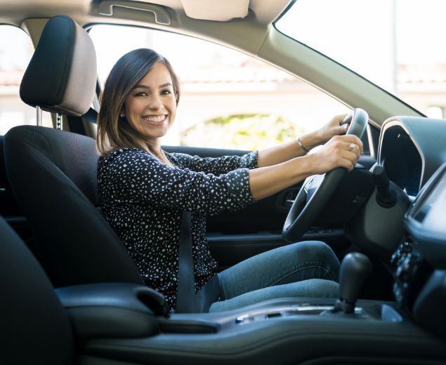 woman smiling in her new car image